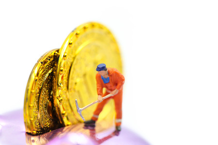 Miniature people : worker digging on gold coins.の写真素材