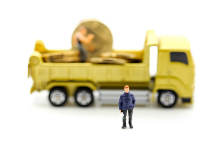 Miniature people : Businessman standing with truck of coins.の写真素材