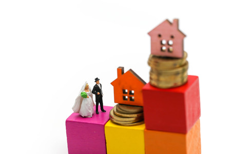 Miniature people : couple of love standing on wooden block with coin and toy house,Concept for property ladder, mortgage,real estate investment, money, love and Valentine's day.の写真素材