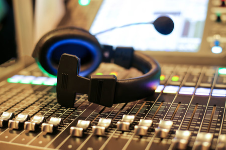 Professional audio Mixer and Professional Headphones in the Recording Studio. Sound Mixing Desk....