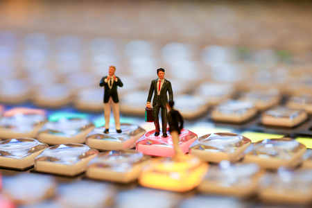 Miniature people : business man standing  on the switcher control of Television Broadcast,color buttonsの写真素材