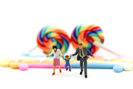 Miniature people : family holding hand with Colorful of candies and lollipops,education and food...