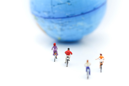 Miniature people : riding bicycle with world map,Sport, Travel and business concept.