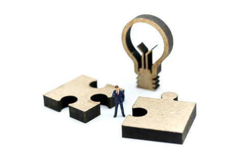 Miniature people : businessman standing with jigsaw puzzle pieces ,Business vision concept.