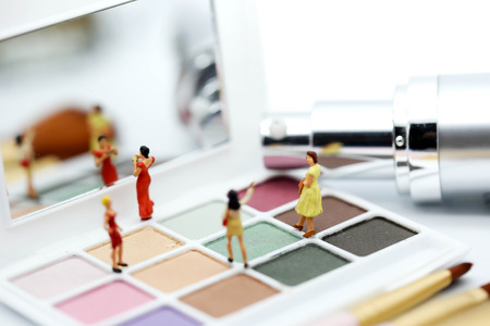 Miniature people : beautiful woman and friend with Makeup products with cosmetic beauty products.の写真素材