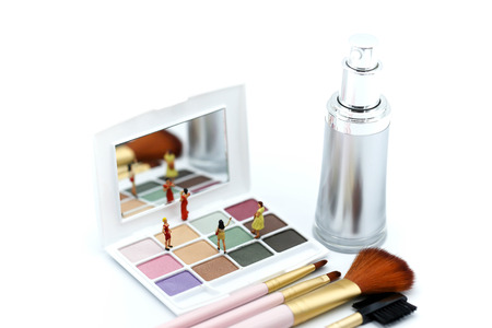 Miniature people : beautiful woman and friend with Makeup products with cosmetic beauty products.の写真素材