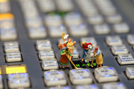 Miniature people : Maid or Housewife cleaning on Switcher buttons in studio TV station, Audio and Video Production Switcher of Television Broadcast.の写真素材
