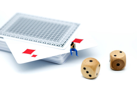 Miniature people : businessman throwing dice and sitting on playing card , Gambling and casino...