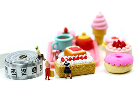 Miniature people : Beautiful womans and sweet dessert with measuring tape,concept of healthy lifestyles and nutrition.の写真素材
