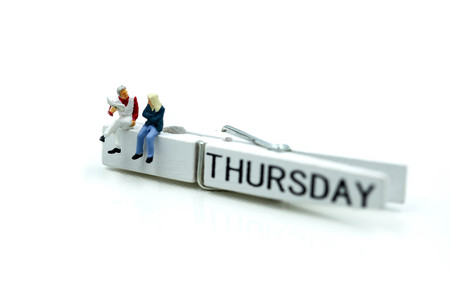 Miniature people : people feeling and sitting on list of thursday.の写真素材
