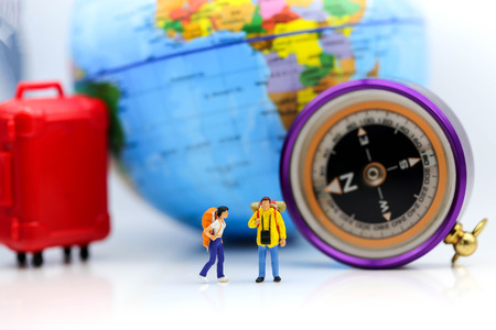 Miniature figure : Close up of group of  traveler standing with compass and world map, backpack and travel concept.の写真素材