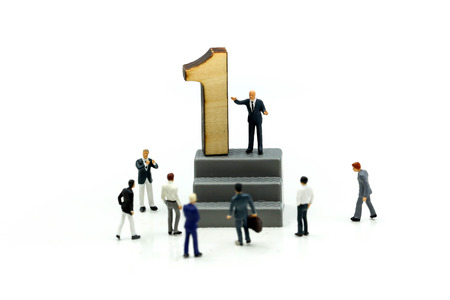 Miniature people : Businessman standing with wooden number of 1,to be the first,Business competition Concept.の写真素材