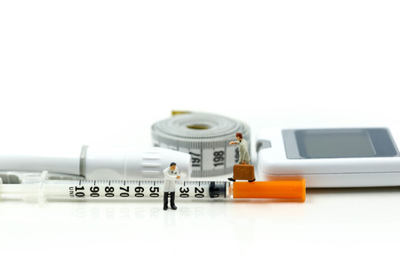 Miniature people : Doctor and businessman look a watch  with Glucose meter diabetes test and Syringe with measuring tape concept of diabetes  healthy lifestyles and nutritionの写真素材
