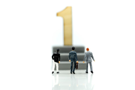 Miniature people : Businessman standing with wooden number of 1,to be the first,Business competition...