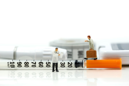 Miniature people : Doctor and businessman look a watch  with Glucose meter diabetes test and Syringe with measuring tape concept of diabetes  healthy lifestyles and nutritionの写真素材