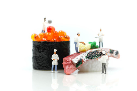 Miniature people : Chef with Salmon egg on sushi nigiri roll on white background.の写真素材