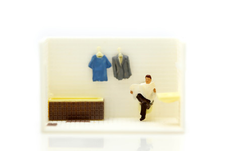 Miniature people : businessman reading newspaper sitting in bathroom,relax time concept.の写真素材