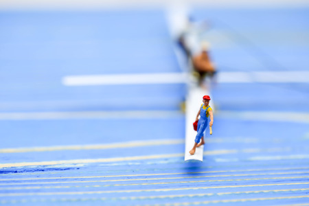 Miniature people : man fishing on a lake from the boatの写真素材