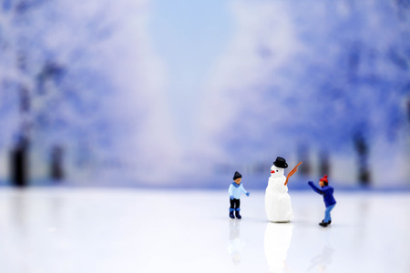 Miniature people : Snowman  and children people playing around snow winterの写真素材