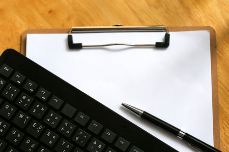 Modern office table with keyboard,pen, notebook on wooden background top view mock-uの写真素材