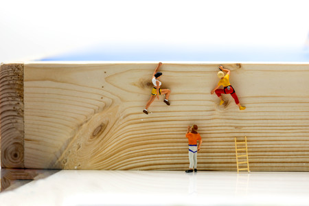 Miniature people. : climbing ladders to get to the top of the position woodenの写真素材