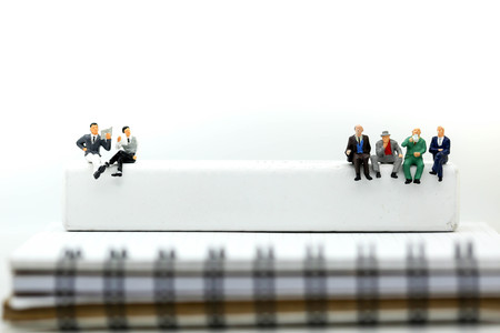 Miniature people : businessman reading newspaper sitting with book and world map,Relax and business concept.の写真素材