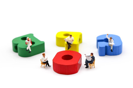 Miniature people : businessman reading a book sitting on Colorful alphabet,education and social background concept.の写真素材