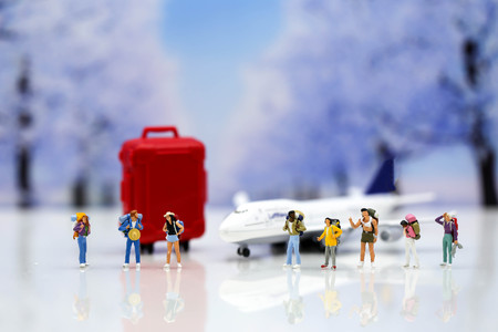 Miniature people : Traveler backpack with airplane,worldmap,luggage of snow winter background.の写真素材