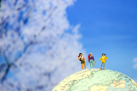 Miniature people : Traveler backpack standing on worldmap of  snow winter background.の写真素材