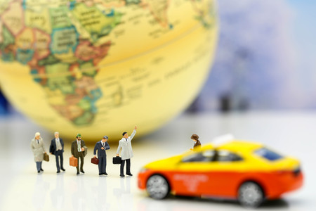 Miniature people : businessman waiting for a taxi in front of the airport,business meeting concept.