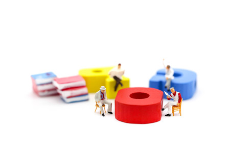 Miniature people : businessman reading a book sitting on Colorful alphabet,education and social...