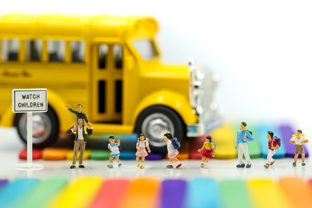 Miniature people : A group of young children getting on the schoolbus with Colorful ice cream sticks...