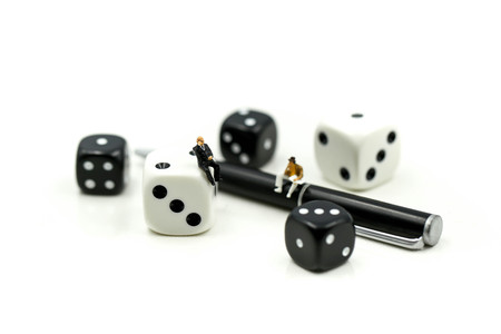 Miniature people : businessman standing with Black and white dices,Business competition Concept.
