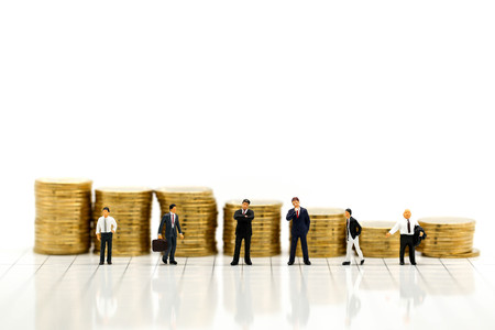 Miniature people : Businessman and friend with stack of coins,Business concept.の写真素材