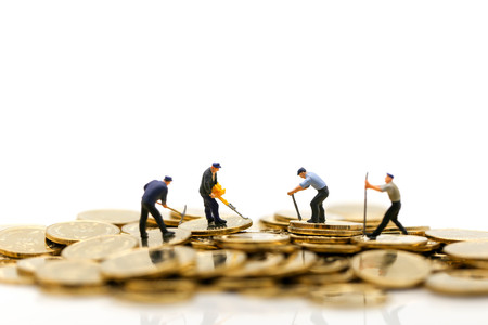 Miniature people : worker digging on coins with house,Money, Financial, Business Growth concept.の写真素材
