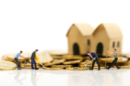 Miniature people : worker digging on coins with house,Money, Financial, Business Growth concept.の写真素材