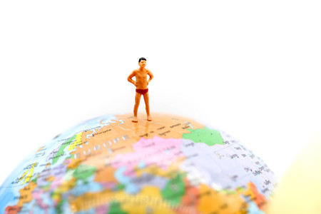 Miniature people wearing swimsuit relaxing on book and world map background,holiday, vacation concept.の写真素材