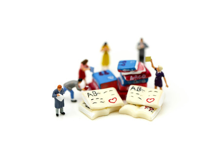 Miniature people : reading a book using as background education or business concept.