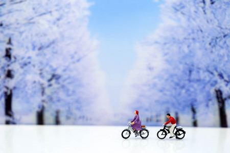 Miniature people : Travelers riding bicycle with winter background,traveling or exploring the world, budget travelの写真素材