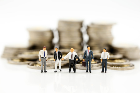 Miniature people : Businessman and Boss with stack of coins using for concept of Boss Day.の写真素材