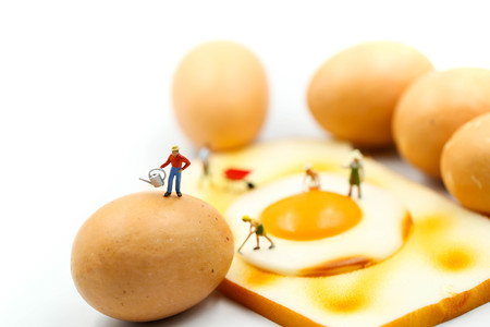 Miniature people : worker cooking  Fried Bread egg using for concept of World egg Day.の写真素材