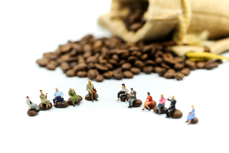 Miniature people : people sitting on Roasted coffee beans using for concept of Cappuccino Day.の写真素材