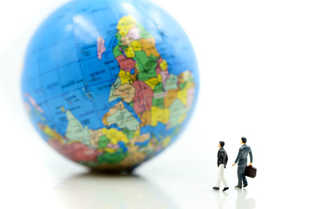 Miniature people : Businessman standing with Global World map balloon,Success Business Due around the world and Strategy Planning concepts.の写真素材