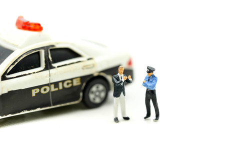 Miniature people : Police officer emergency service car driving street.の写真素材