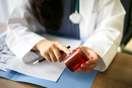 Beautiful physician medicine doctor or pharmacist  reading notes of  boxes medicine,Medical care, pharmacy or insurance conceptの写真素材