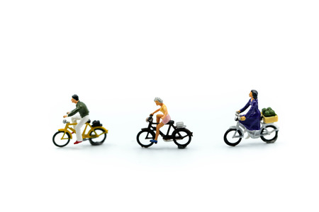 Miniature people : man and friend ride bicycle on white background.
