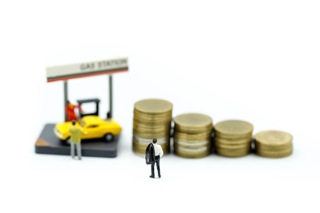 Miniature people : Businessman On Gas Station with coins,business gas station economy concept.