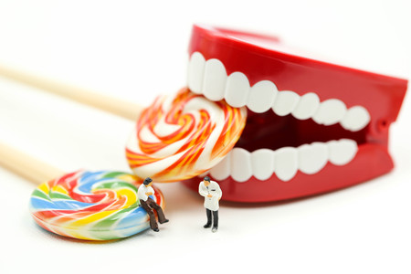 Miniature people : Dentist examining a patient's teeth with patient and sweet lollipops,healthcare medical concept.の写真素材