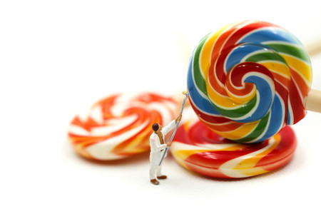 Miniature people : worker painting with colorful sweet candy lollipop.の写真素材