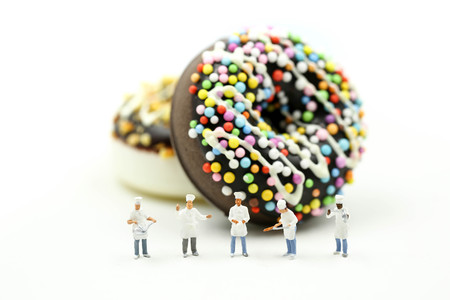 Miniature people : Chef offers a donut dessert with colorful sprinklesの写真素材